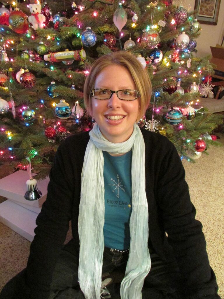 lady wearing scarf sitting in front of Christmas tree