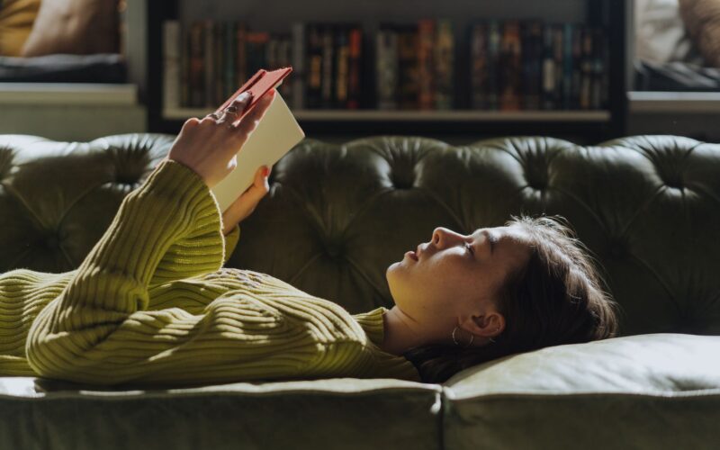 person laying down reading a book