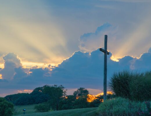cross with light coming from behind clouds