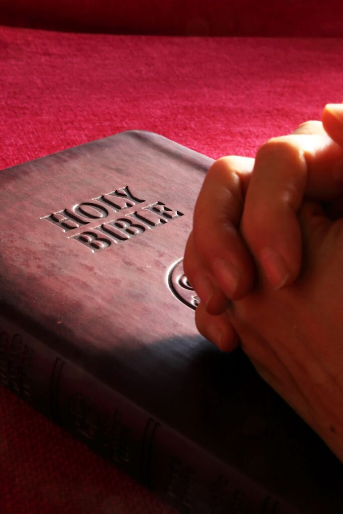 Bible with praying hands
