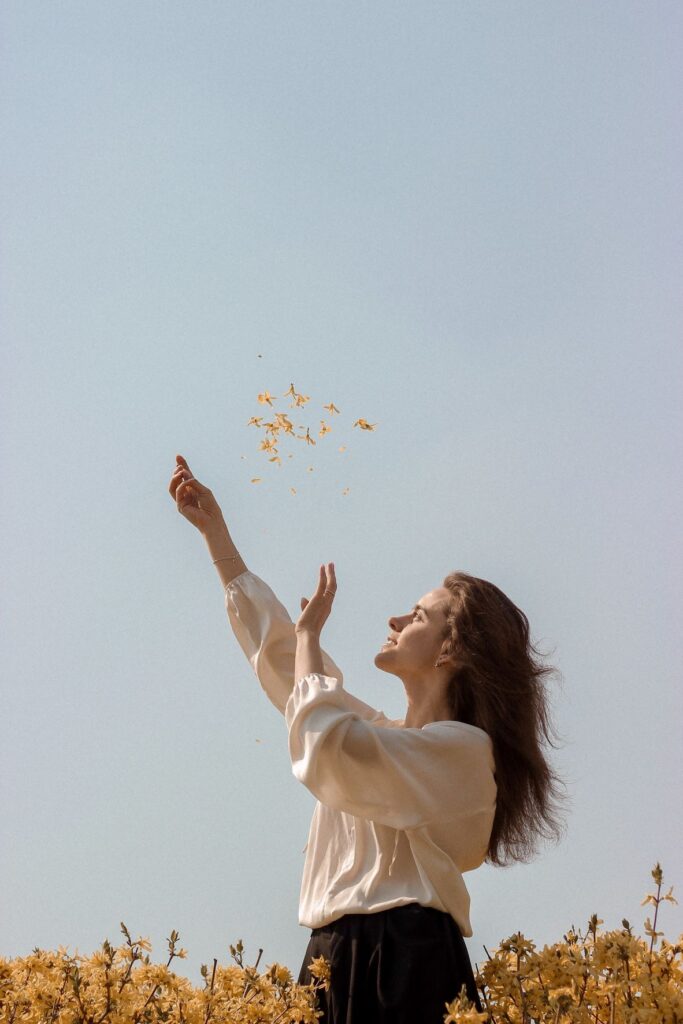 lady throwing petals up in the blue sky