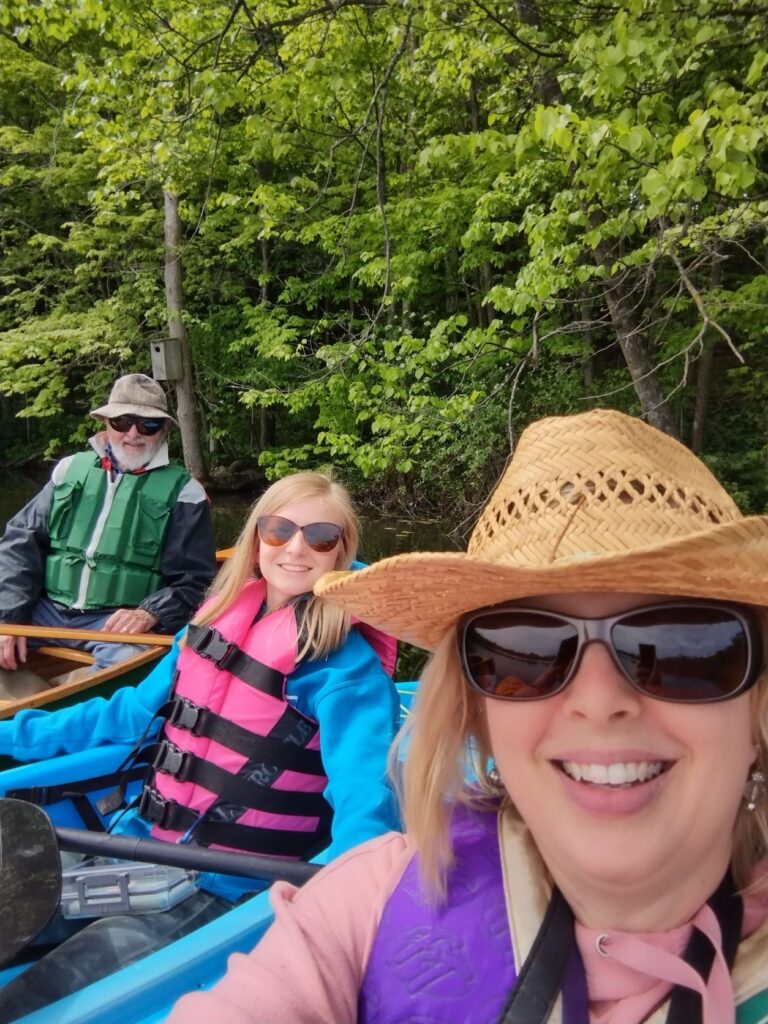 Three people lined up in their kayaks on a lake